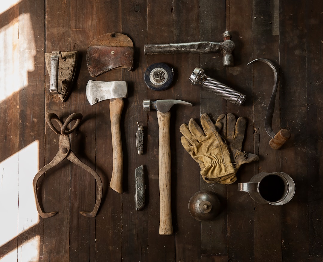 A neatly organized tool kit with essential tools like a hammer, screwdriver, pliers, and measuring tape on a wooden workbench.