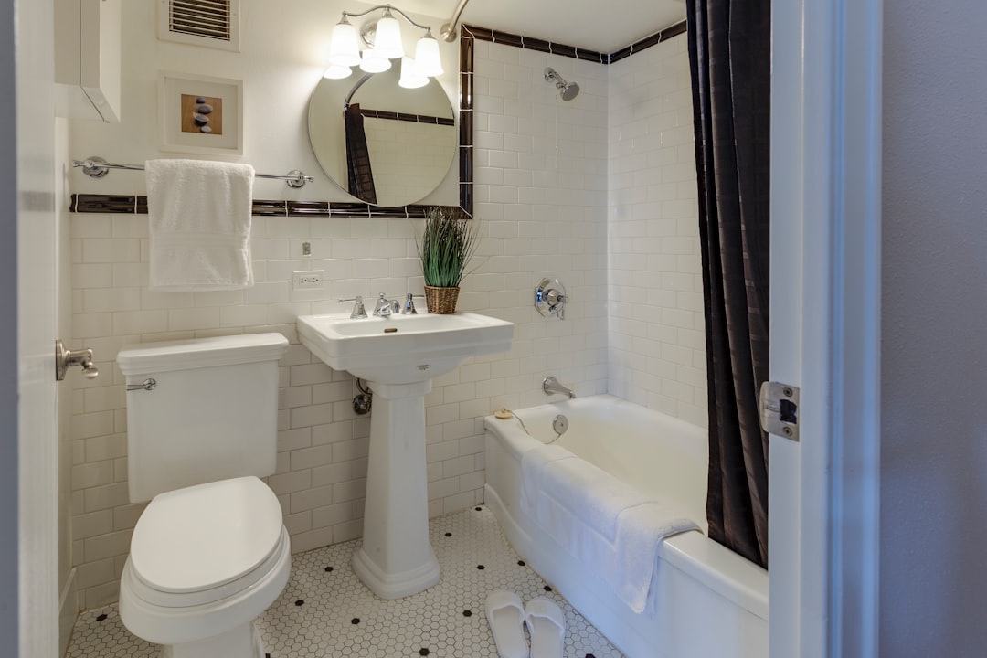 A neatly organized small bathroom with minimalistic decor, showcasing efficient storage solutions and a spacious feel.